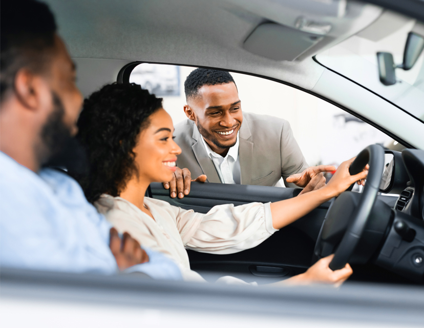car salesman with clients sitting in car