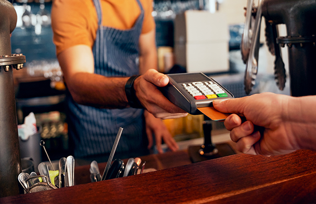 patron using a credit card machine held by an employee
