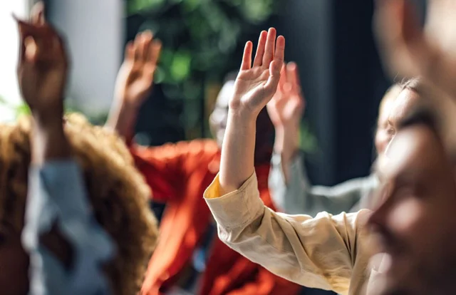 group of people raising their hands