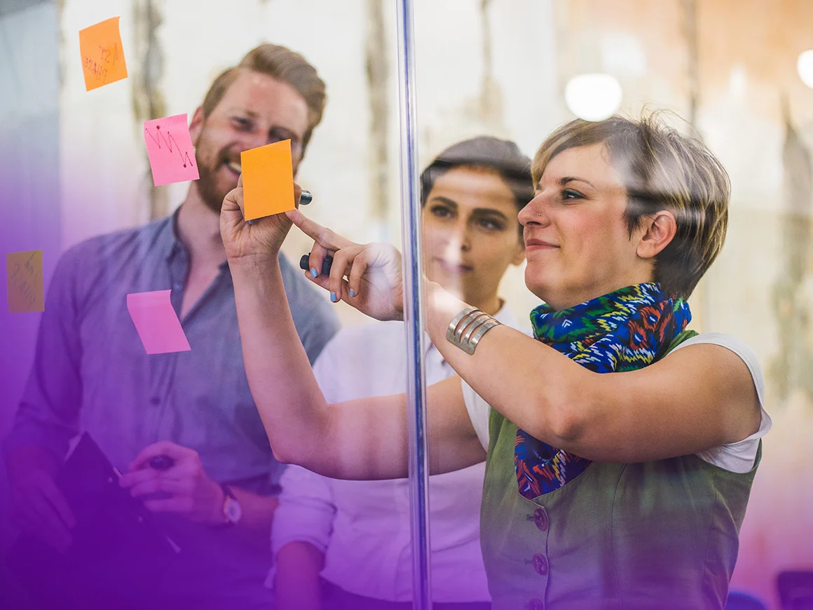 group of people looking at sticky notes