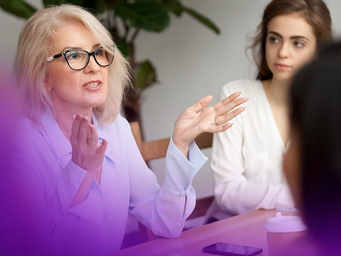 woman wearing black glasses gesturing in a meeting