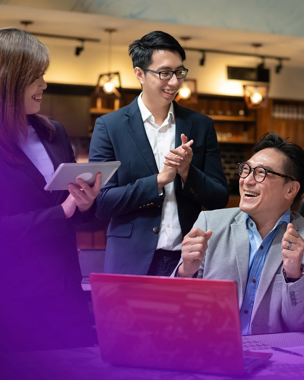 group of people celebrating around a laptop