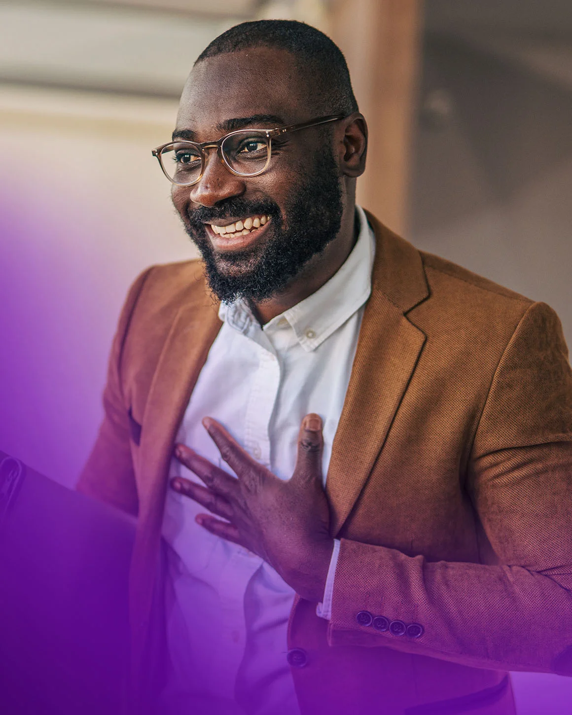 man wearing a blazer gesturing and smiling