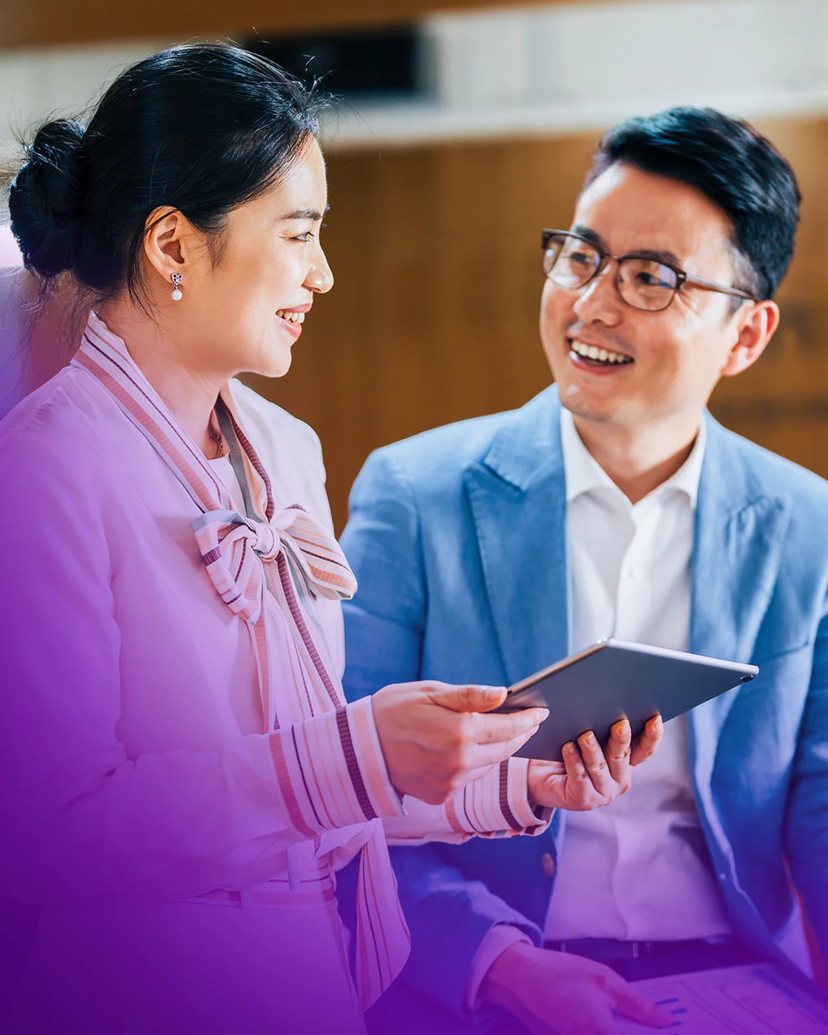 two people holding a tablet while talking