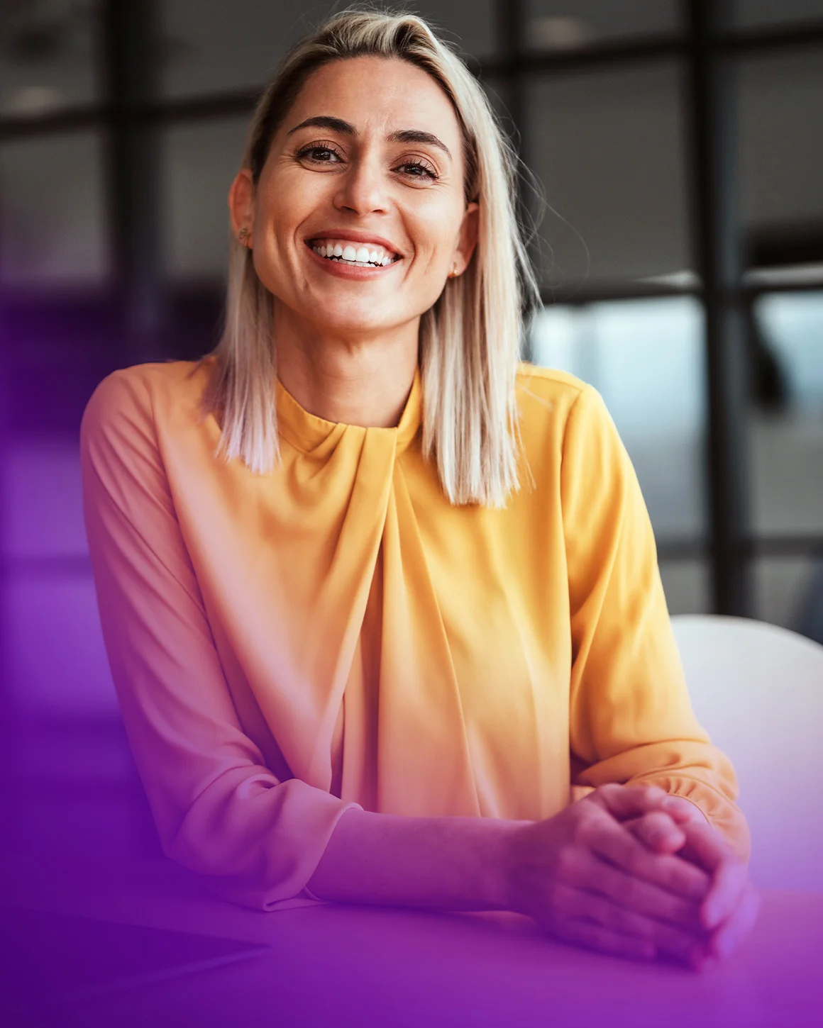 woman in yellow shirt smiling at camera